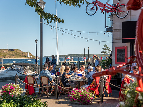 Außenansicht eines Restaurants in Halifax und mehrere Menschen, die mit Freunden und Familienmitgliedern essen 