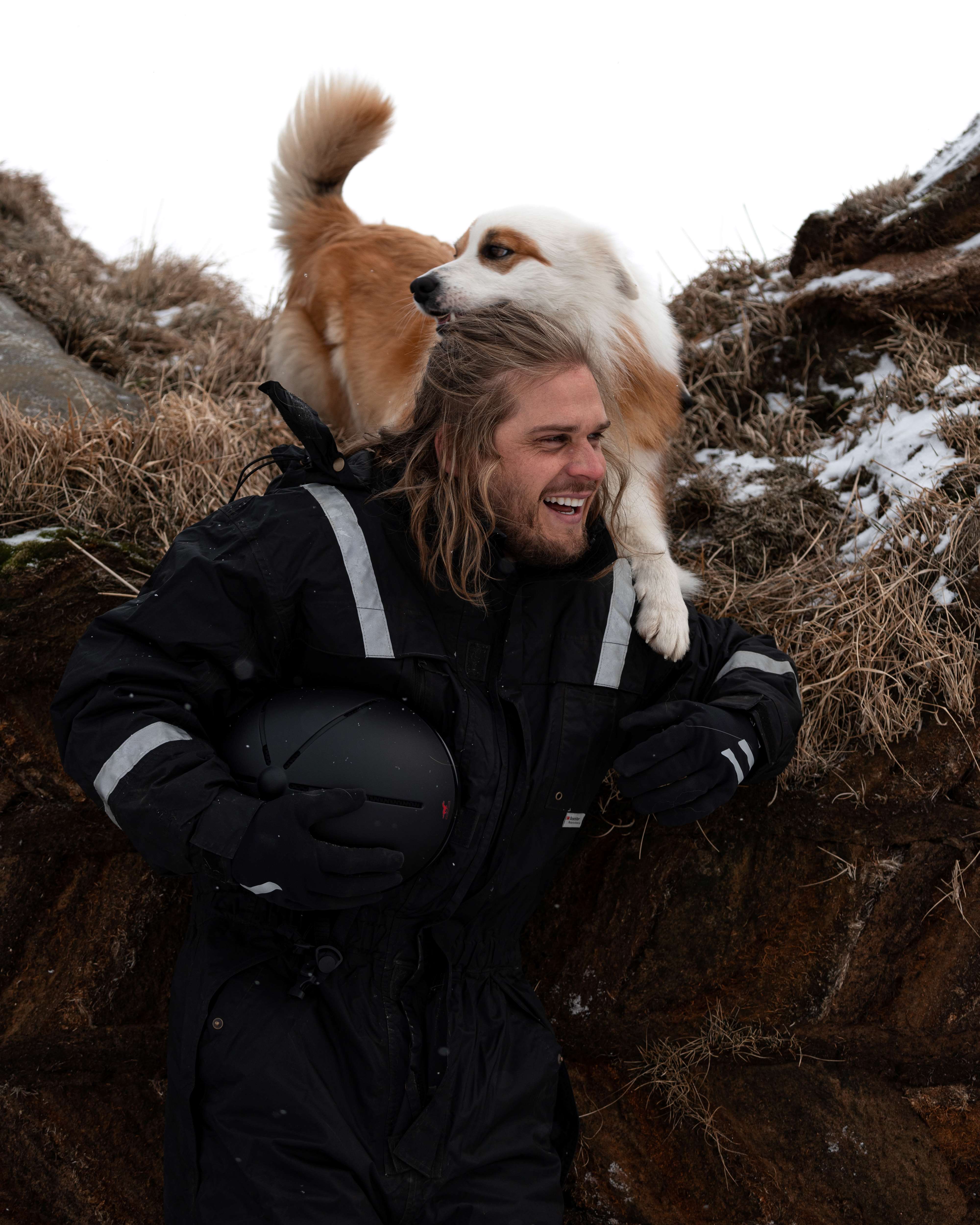 Rúrik Gíslason plays with a dog on a horse-riding farm in North Iceland.