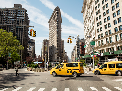 The iconic yellow cabs in New York making their way through the high rise city