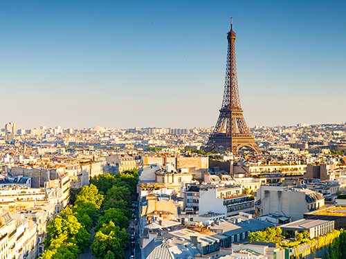 A cityscape of Paris as pictured from overground, with the Eiffel Tower standing tall amidst the city buildings