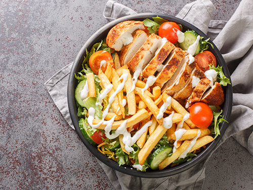 A picture of the famous Pittsburgh salad, placed upon a grey table cloth and table 