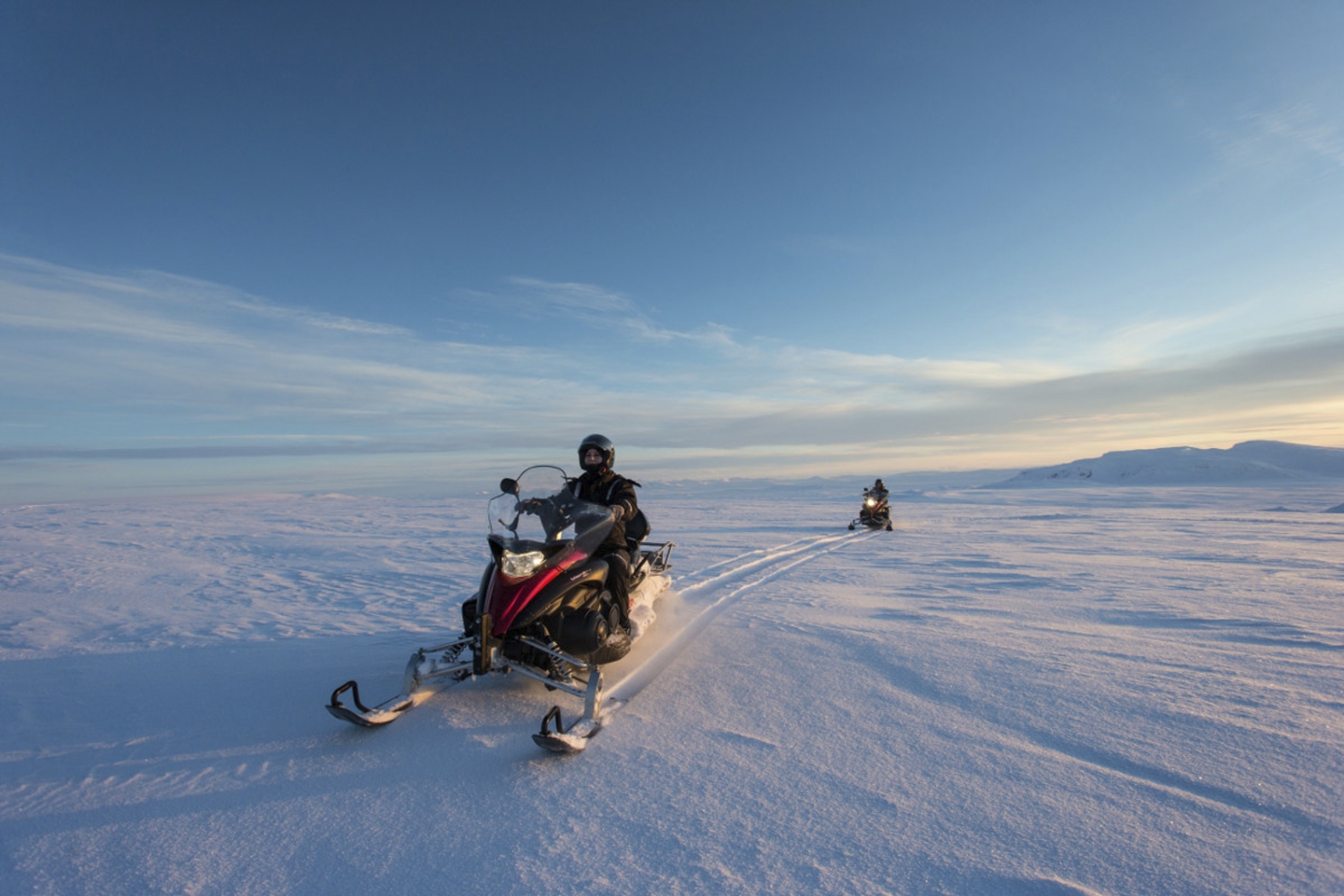 Image of people riding snowmobiles on the snow, on Langjökull glacier.