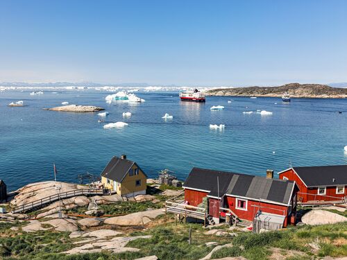 traditional fisherman's houses by the coast with icebergs in the water