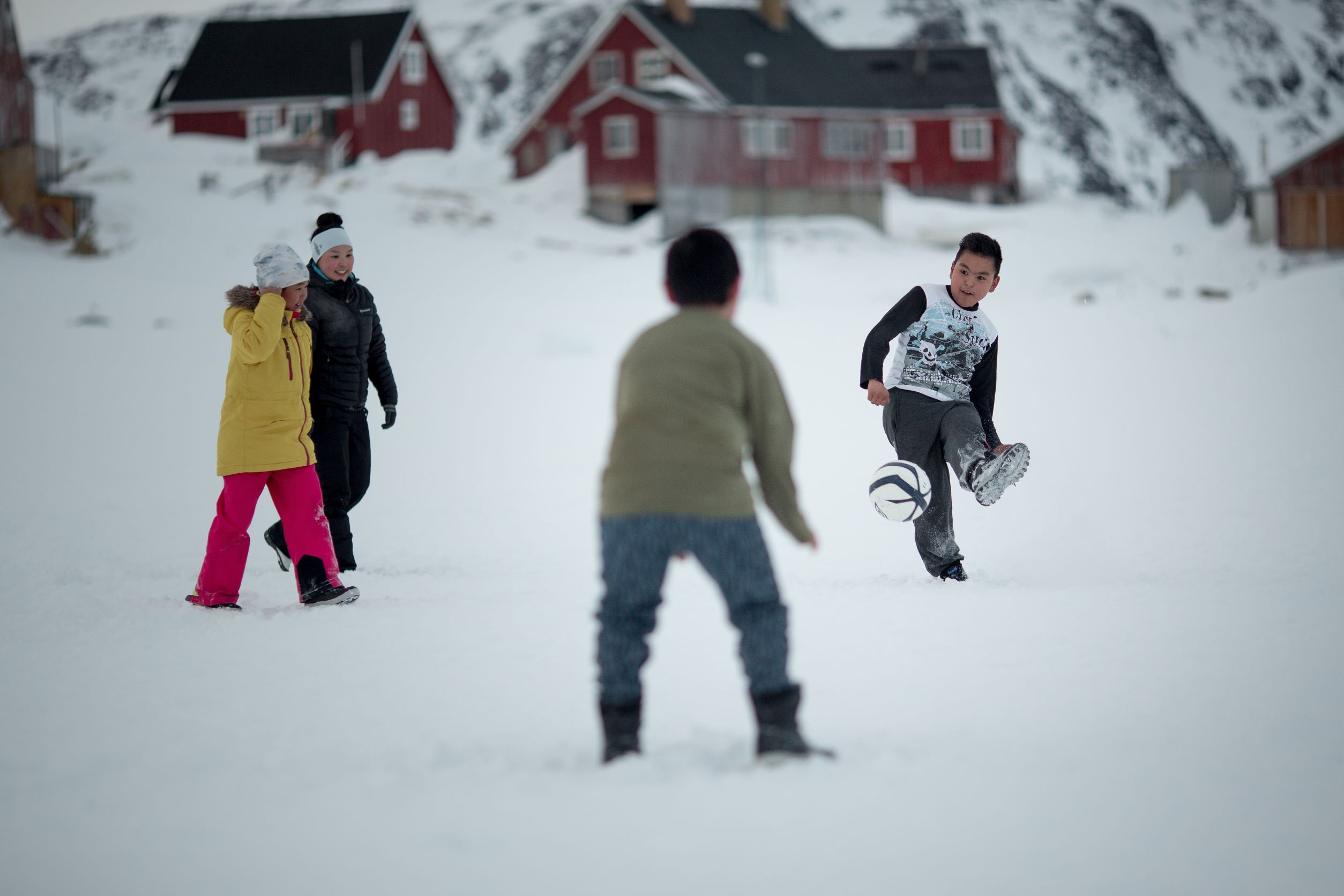 Kids playing football on the sea ice in Kulusuk