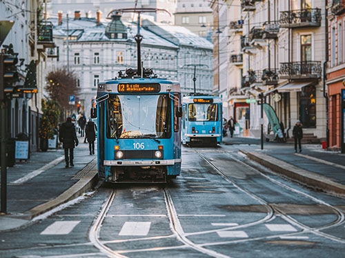 A blue tram on a street in Majorstuen in Oslo