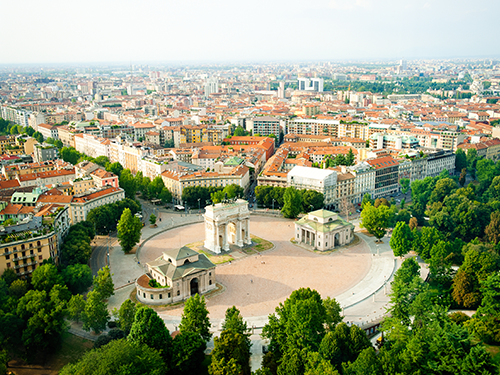 A birds eye view of the city of Milan, in Italy, with the Arco della Pace in front and center shot 