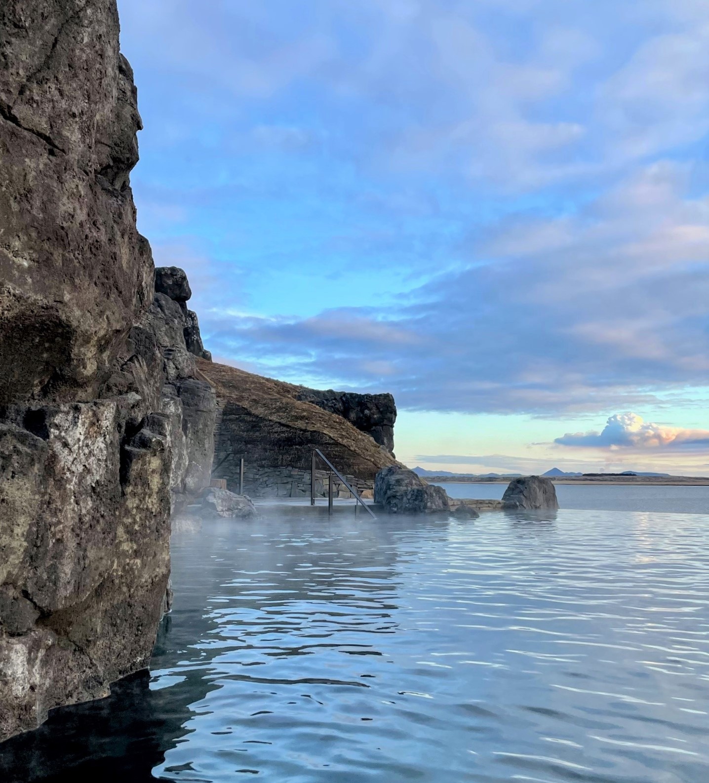 The Sky Lagoon in Reykjavik pictured from within looking out onto the large body of water nearby