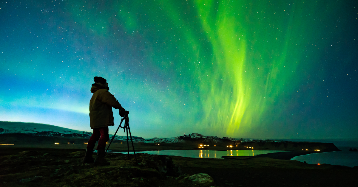a person is pictured photographing the northern lights in Iceland