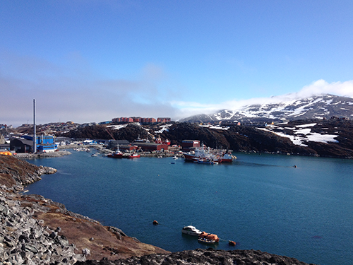 The harbor at Nuuk pictured with snow-capped mountains in the background 