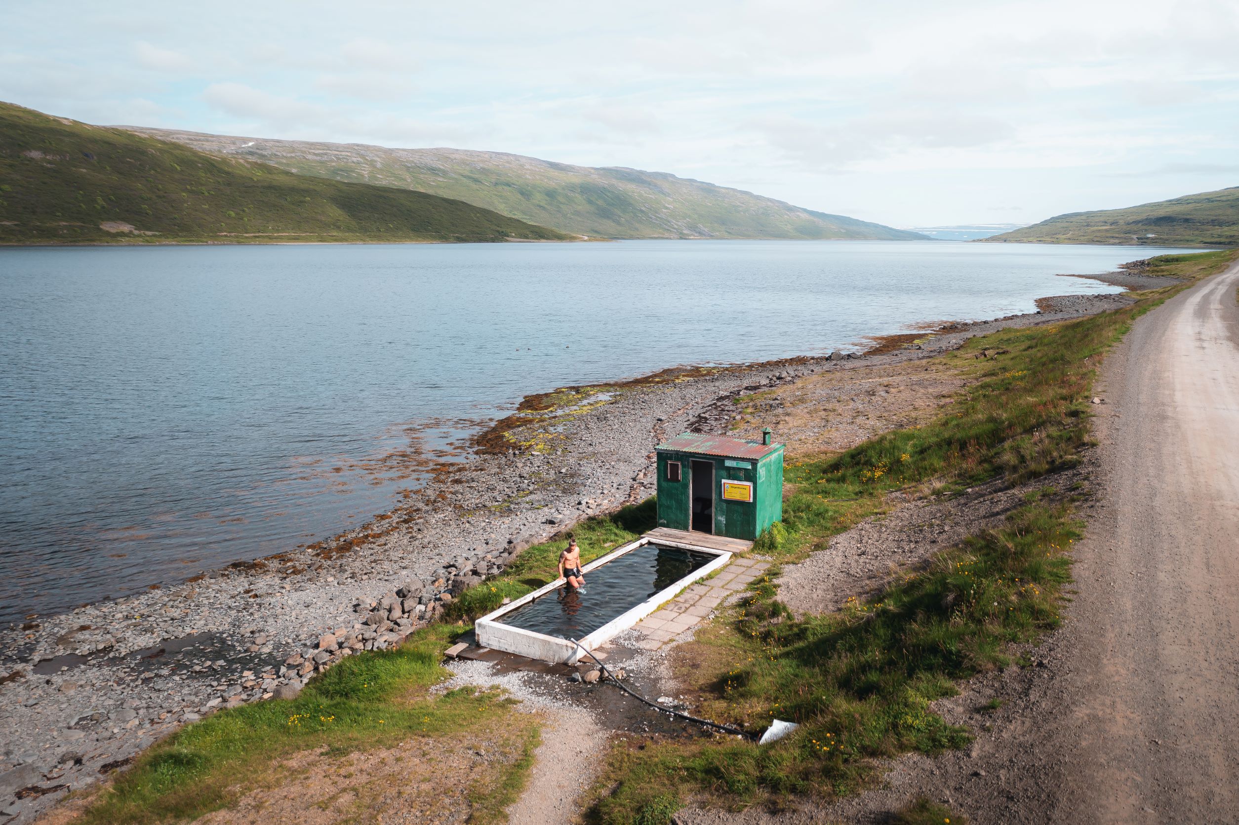 Rurik Gislason at a small outdoor geothermal pool by the side of a fjord