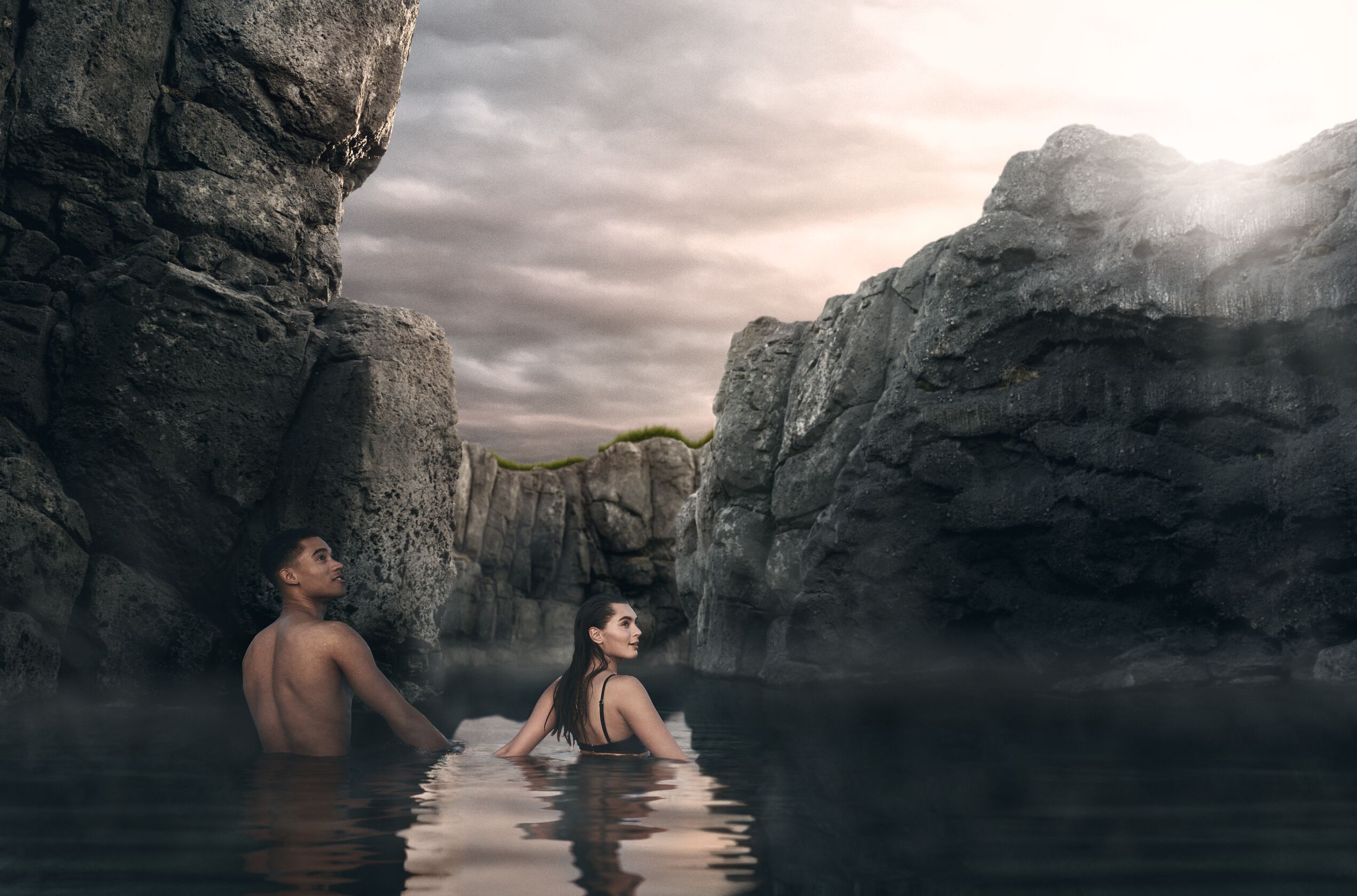 Ein Mann und eine Frau, die in der Felslandschaft der Sky Lagoon stehen.