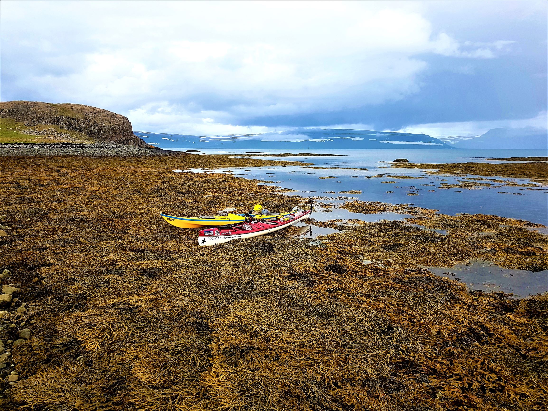 Two kayaks on the seaweed at the shore of Isafjordur in West Iceland