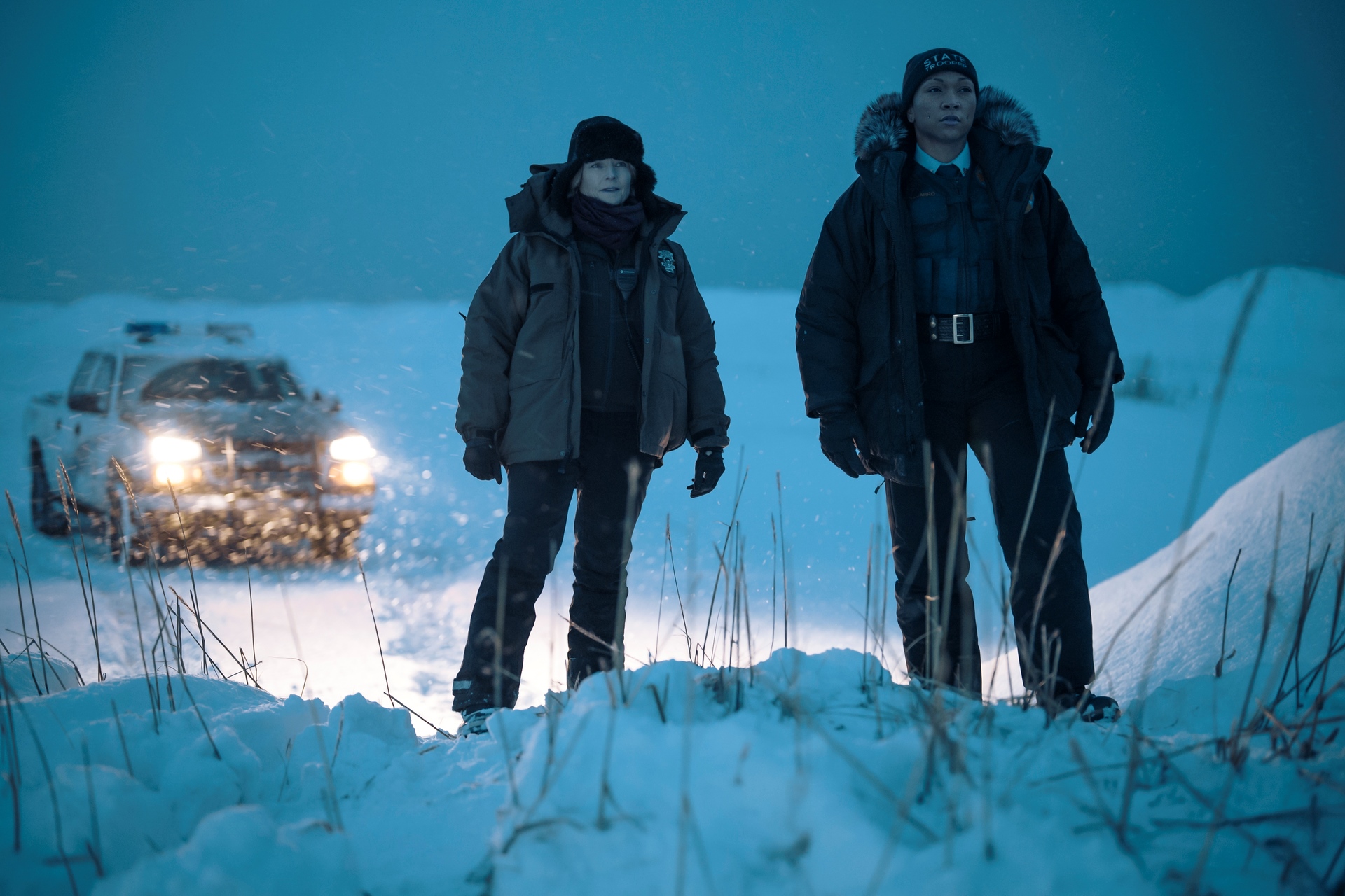 Image from the set of True Detective: Night Country: actors Jodie Foster and Kali Reis pictured in police uniform in snowy landscape