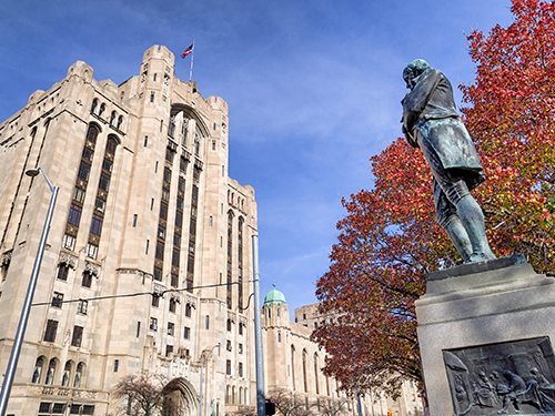 Miðbær Detroit, gömul stytta fyrir framan skýjakljúfinn Masonic Temple, haustlauf á trjánum.