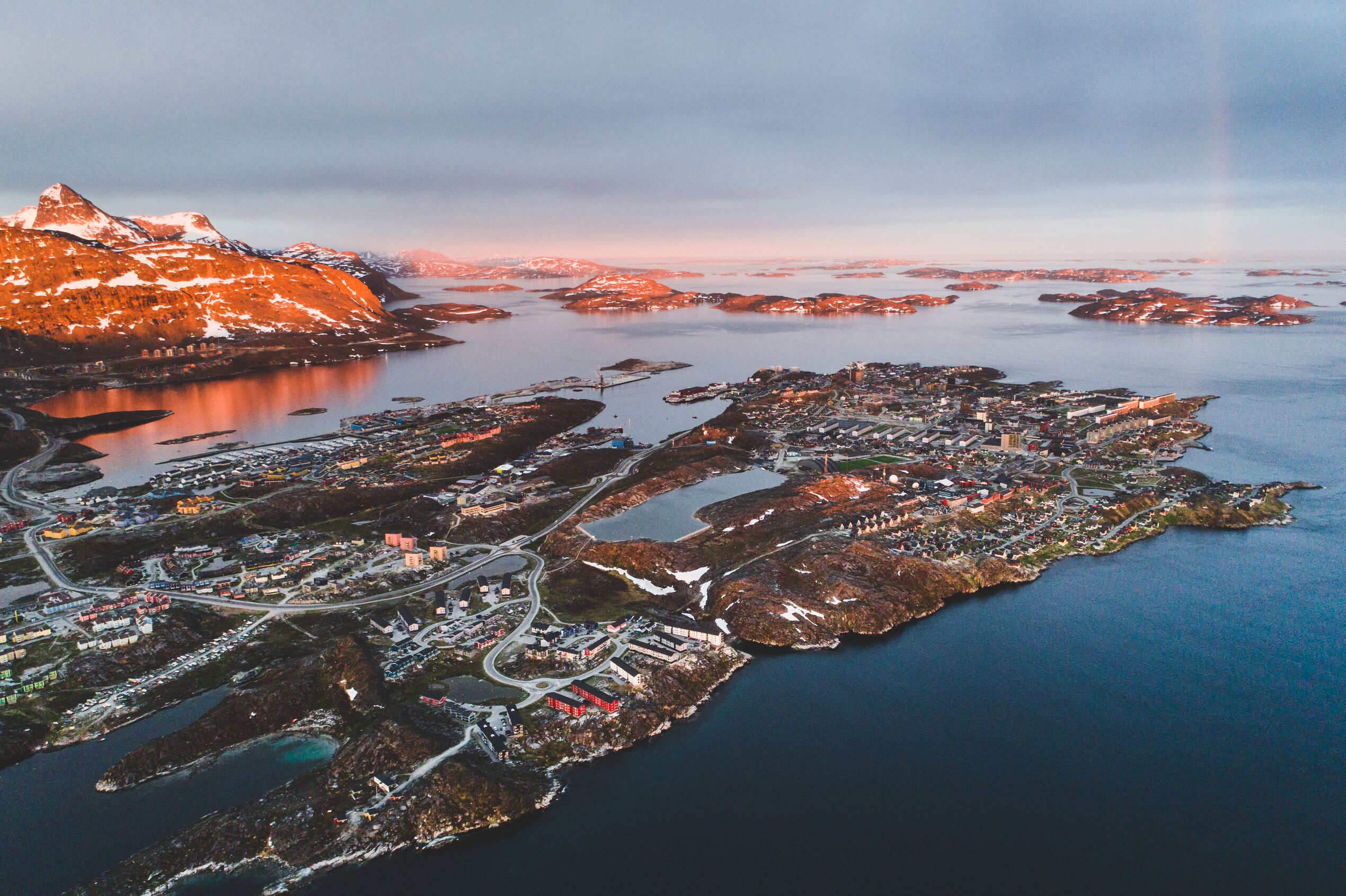 An aerial view of Nuuk in Greenland with the sunset reflecting on the area