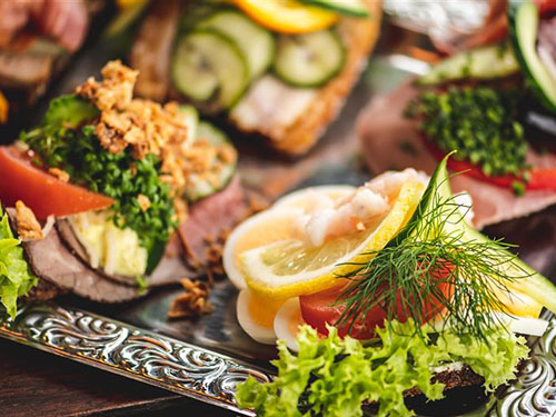 A silver platter with danish open sandwiches, which the locals call Smørrebrød