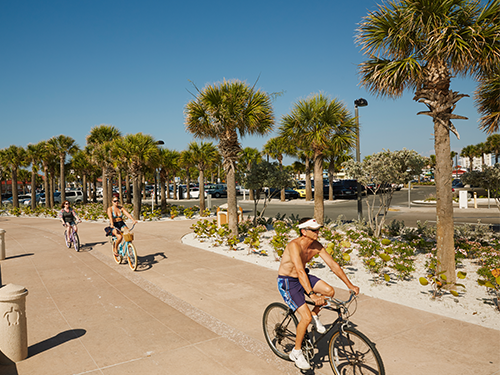 A group of three people cycle on bikes down the streets in Orlando 