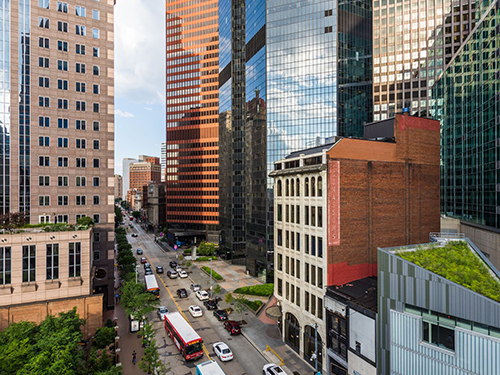 Pittsburgh city traffic makes its way at ground level, with the large sky scrapers all around 