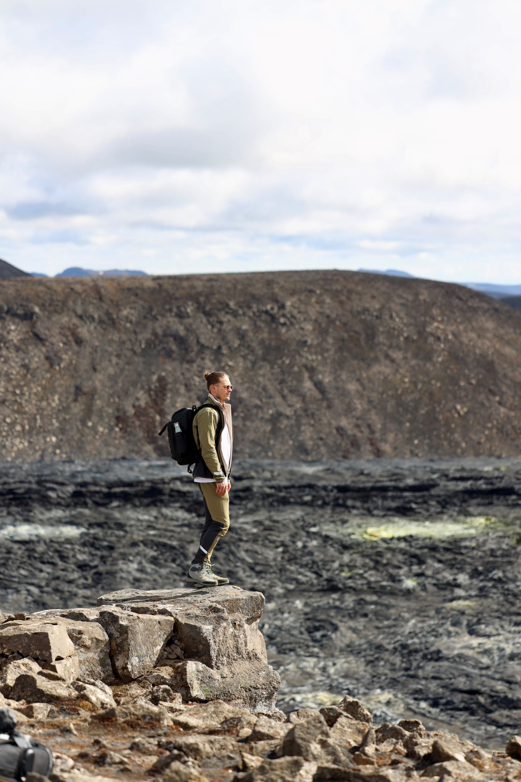 Rurik Gislason stands on rocks surrounded by lava