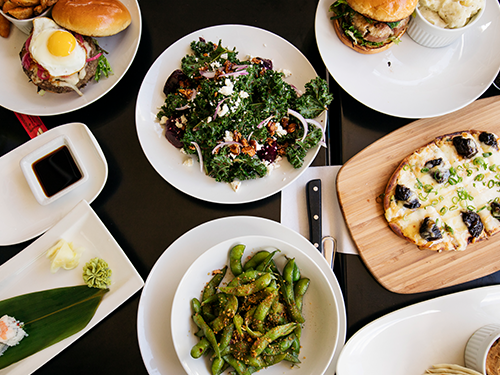 A table with several colourful dishes of food placed on it 