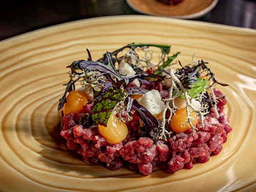 A plate of food from a restaurant in the East of Iceland - beef tartare with egg yolk and feta cheese 