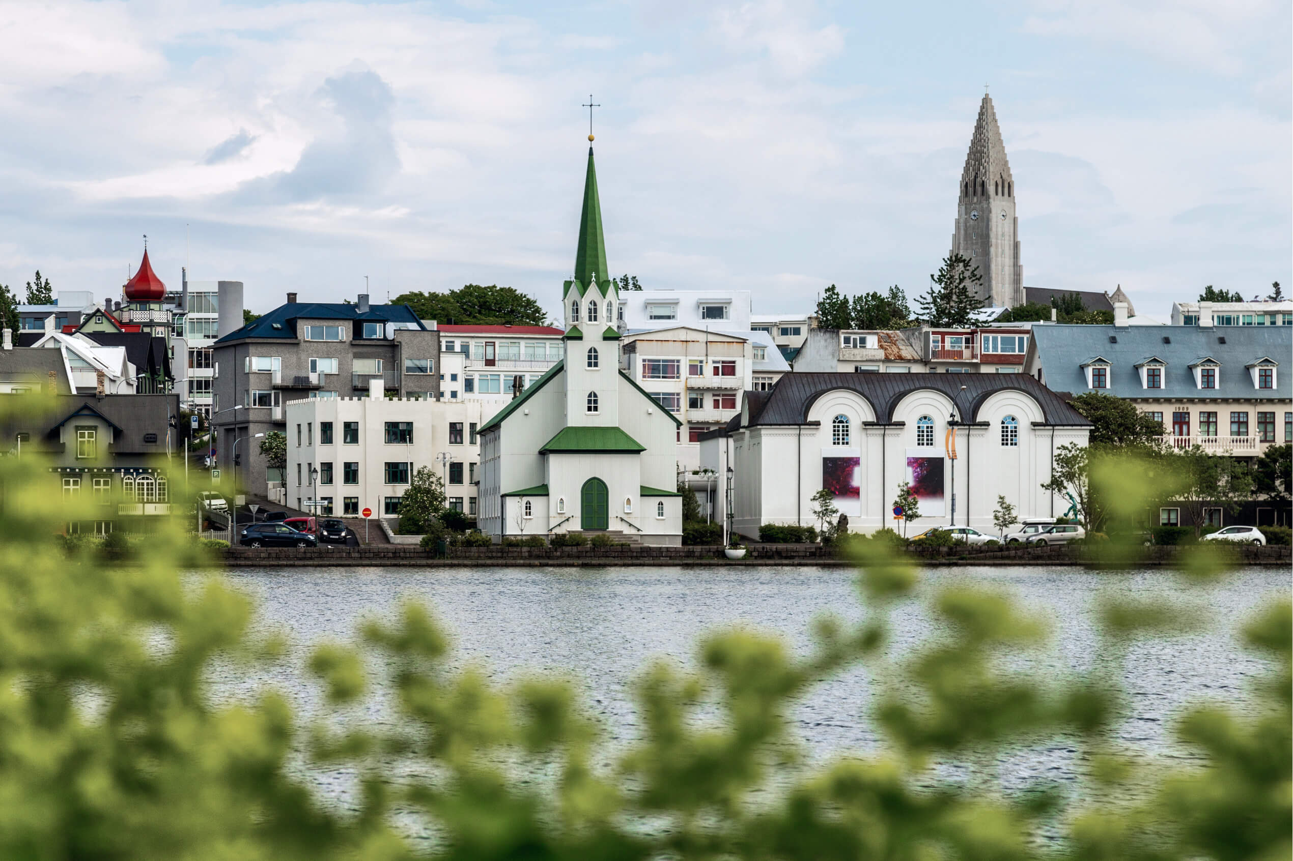 picturesque image of city center of Reykjavík, overlooking the pond, Fríkirkjan, Listasafn Íslands and Þingholt neigborhood in the background.