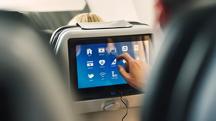 a passenger selects a film from the in-flight entertainment