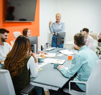 Photo of woman leading a office meeting with 6 people