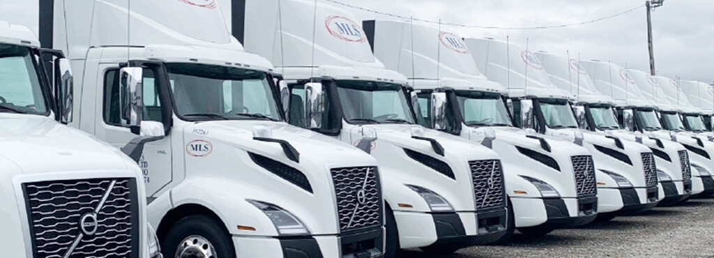 A row of ten parked MLS tractors.