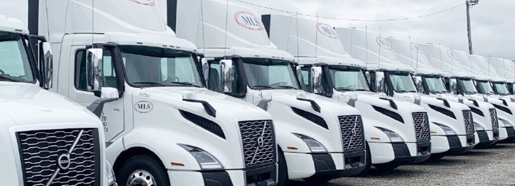 A row of ten parked MLS tractors.