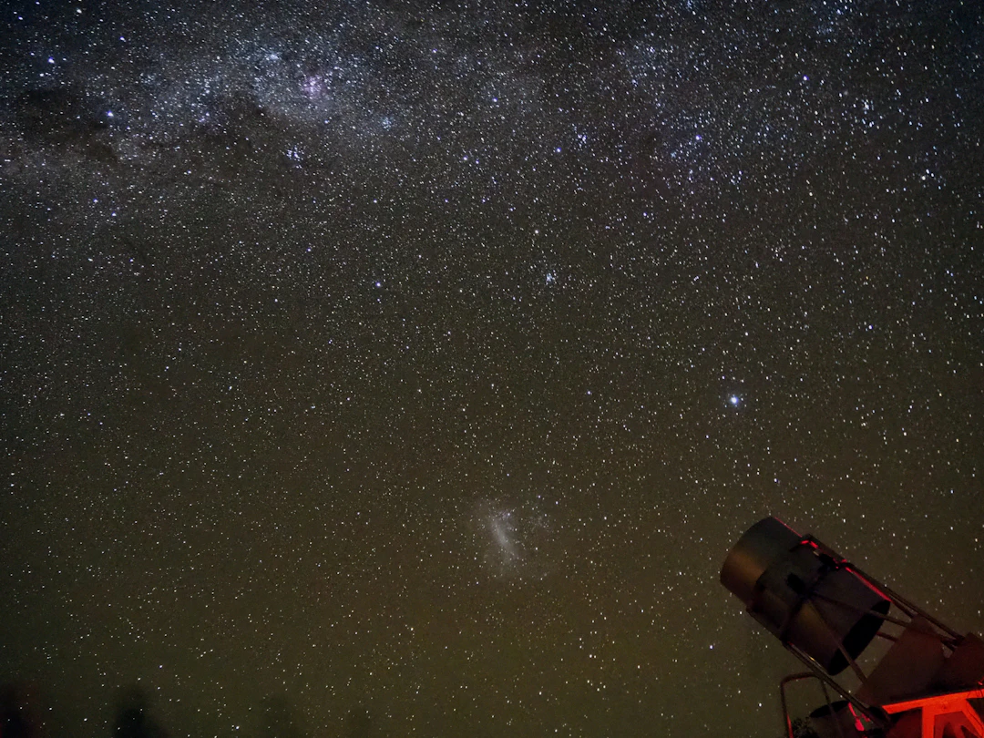 Céu estrelado no Atacama com telescópio para observação astronômica. Monte seu roteiro com pontos na Livelo.