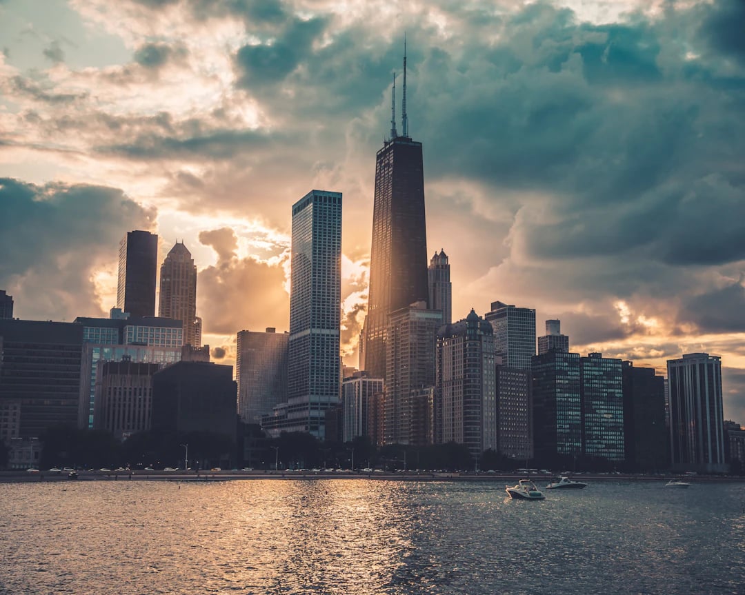 Skyline de Chicago ao entardecer visto da água, com prédios altos sob céu dramático e reflexo no lago. Planeje sua viagem com pontos Livelo.