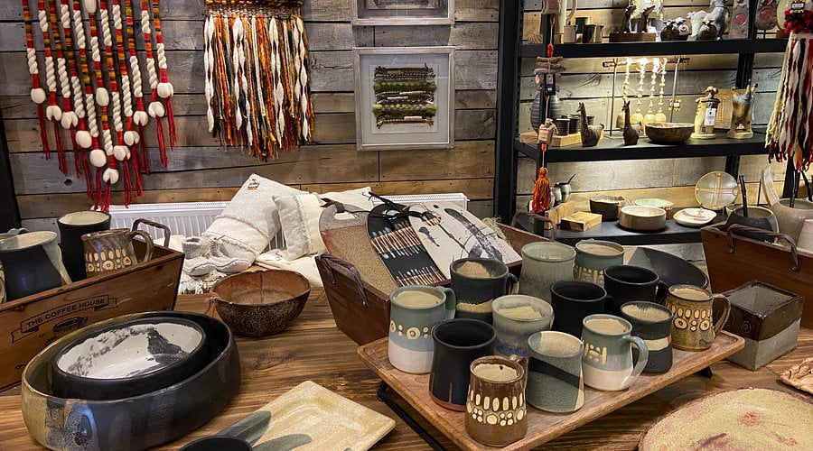 Loja de artesanato em Torres del Paine, Chile, com cerâmicas, canecas e itens decorativos em exposição. Viaje e use pontos Livelo.