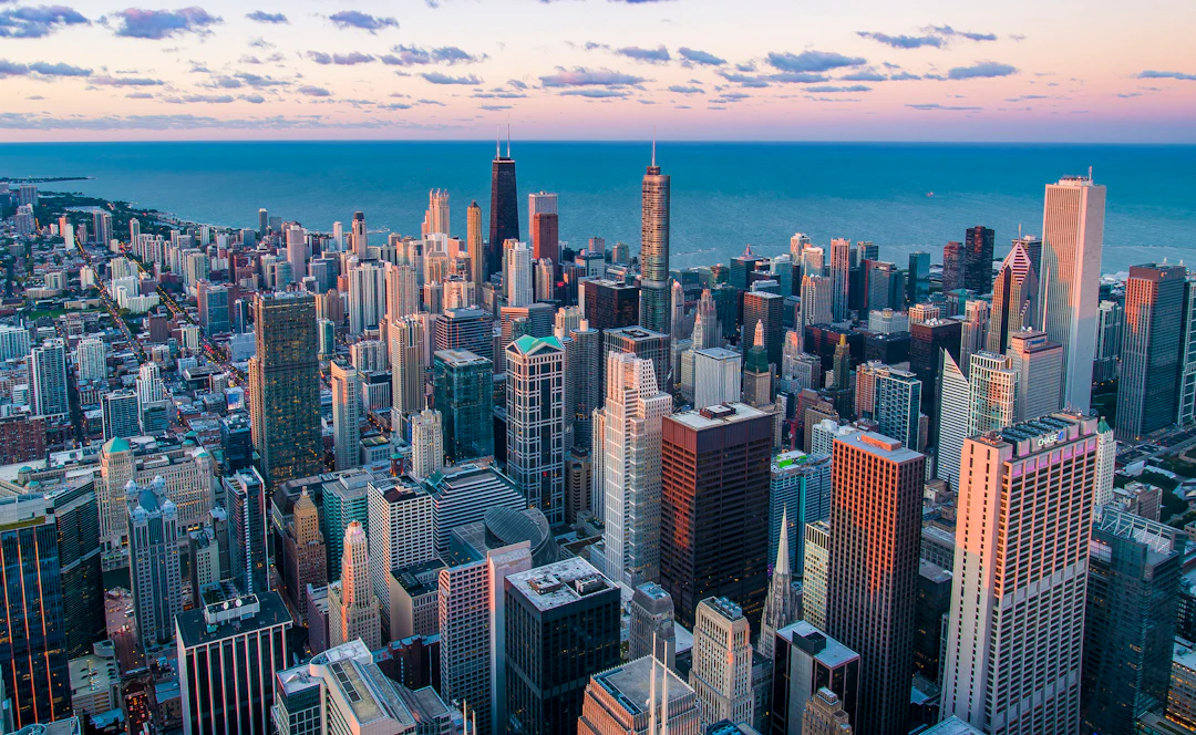 Vista aérea de Chicago com arranha-céus, ruas em grade e o Lago Michigan ao fundo sob luz do fim do dia. Viaje para Chicago com pontos Livelo.