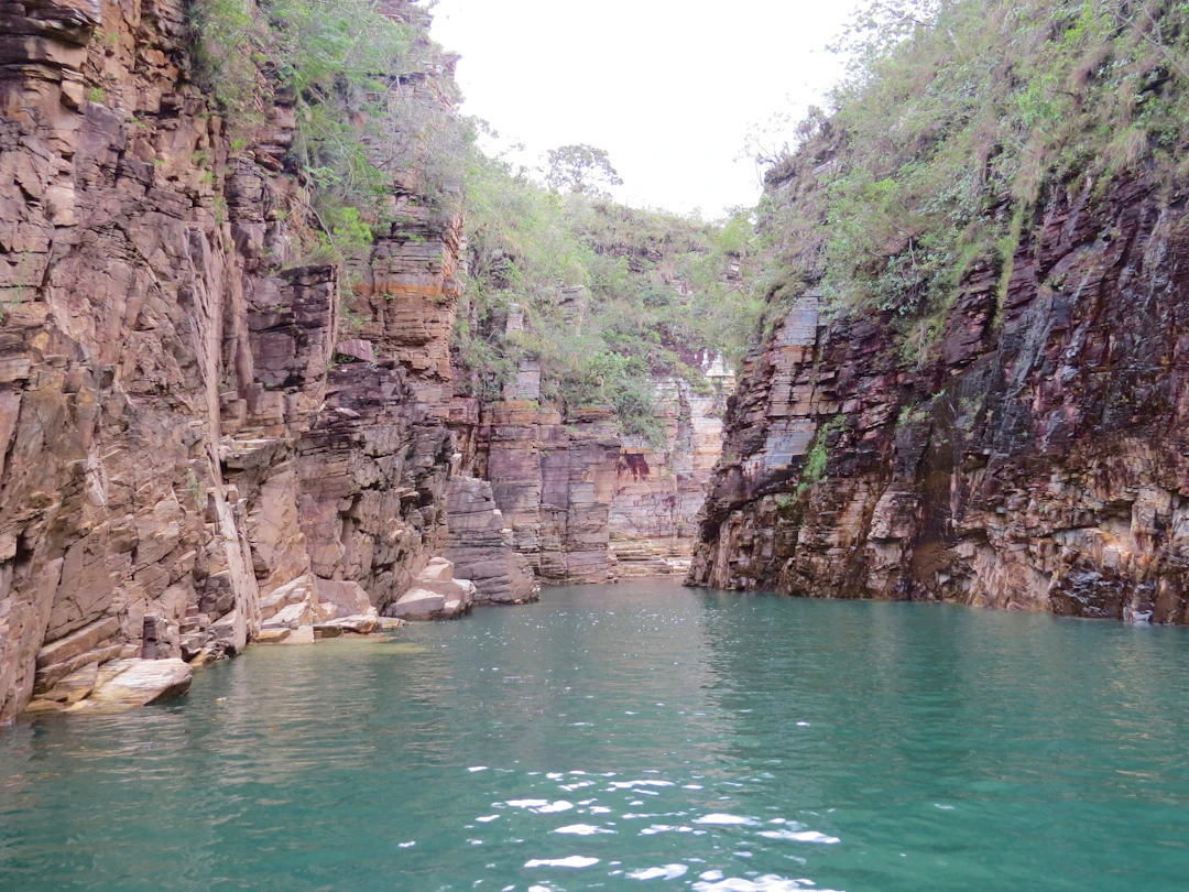 Cânion em Capitólio MG com paredões de pedra e lago de água verde-esmeralda, ideal para passeio de lancha e banho. Planeje sua viagem com pontos Livelo.