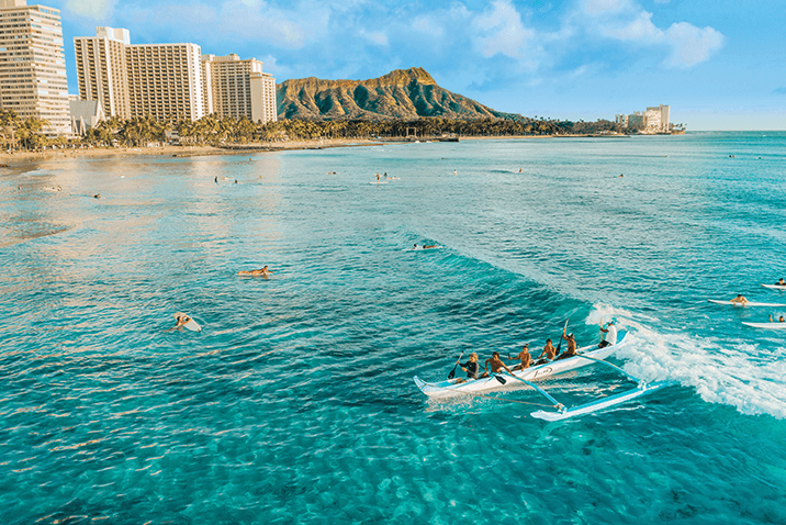 Vacationers in crystal clear Hawaii beach water.