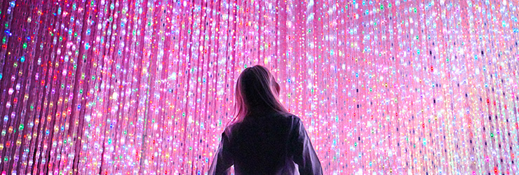 Una persona mirando una pared llena de luces.