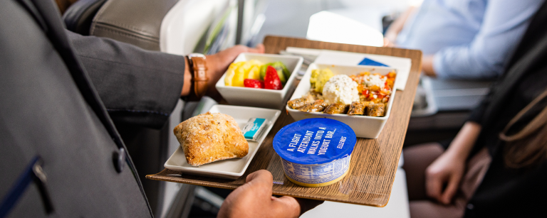 Passenger being served First Class meal.