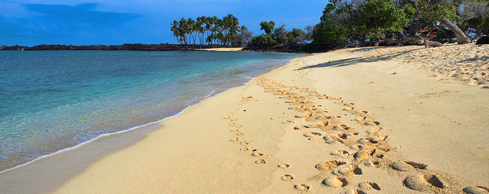 Sunny day on a beach with foot prints all over the sand