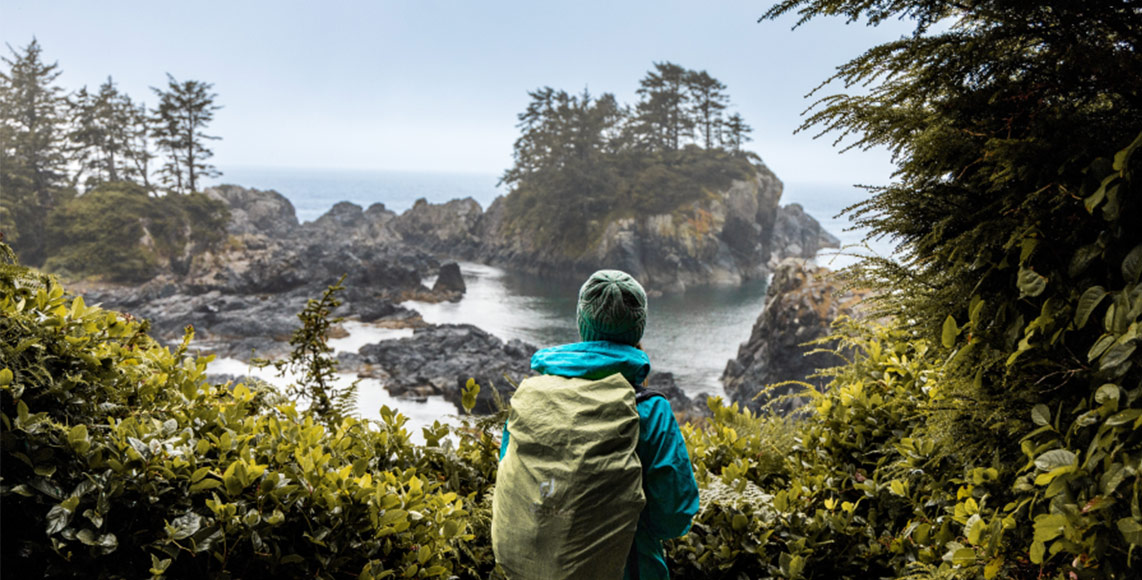 A person looking out into the ocean from a Pacific Northwest beach.