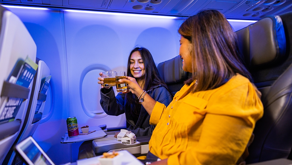 Two guests in First Class enjoying a drink