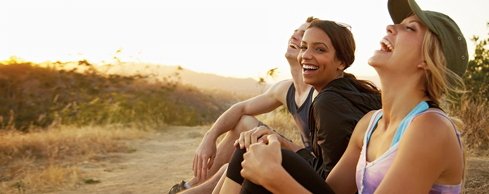 Two women and a man sitting and laughing