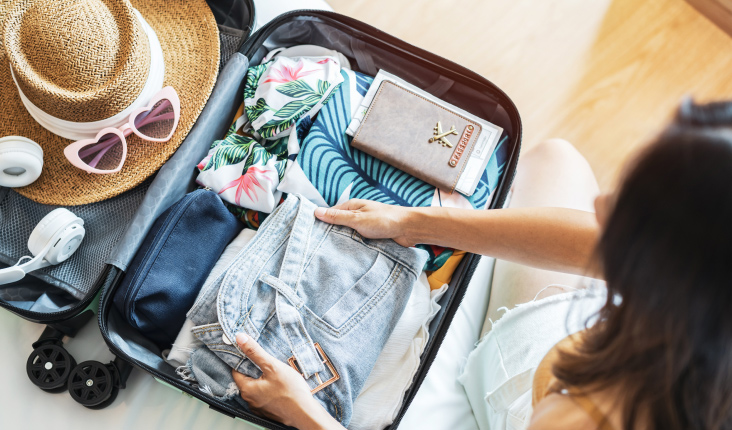 A person packing a suitcase.