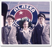 Una foto antigua de 1932 en la que se ve a tres empleados de pie frente a una aeronave.