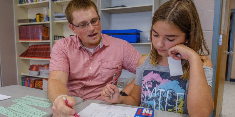 A teacher working one on one with a student.