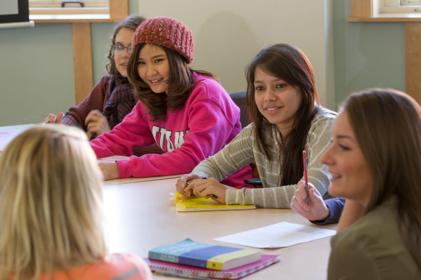 Group of students discuss topics at a table.