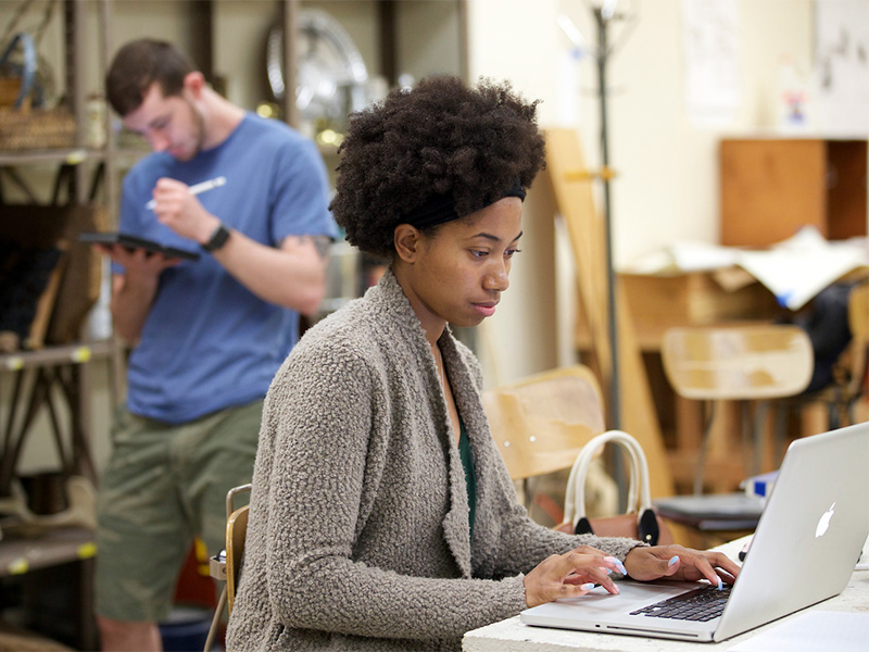 Students working on computer devices in the classroom.