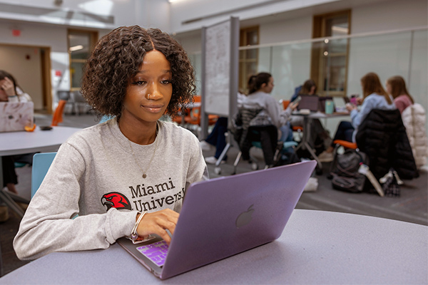 Student at a desk working on a laptop.