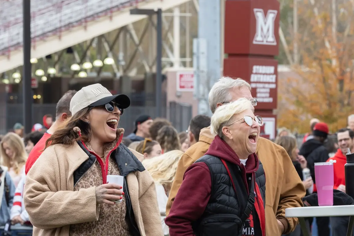family cheering outside of a Miami Football game
