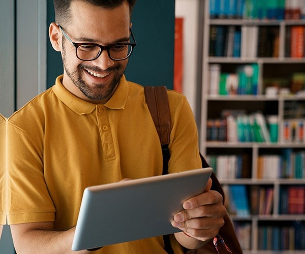Miami University student looking at an iPad in a library.